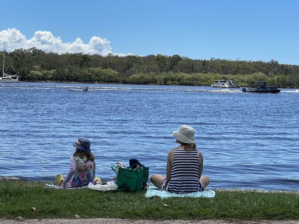 Family sitting by the river on Gympie Terrace Noosaville