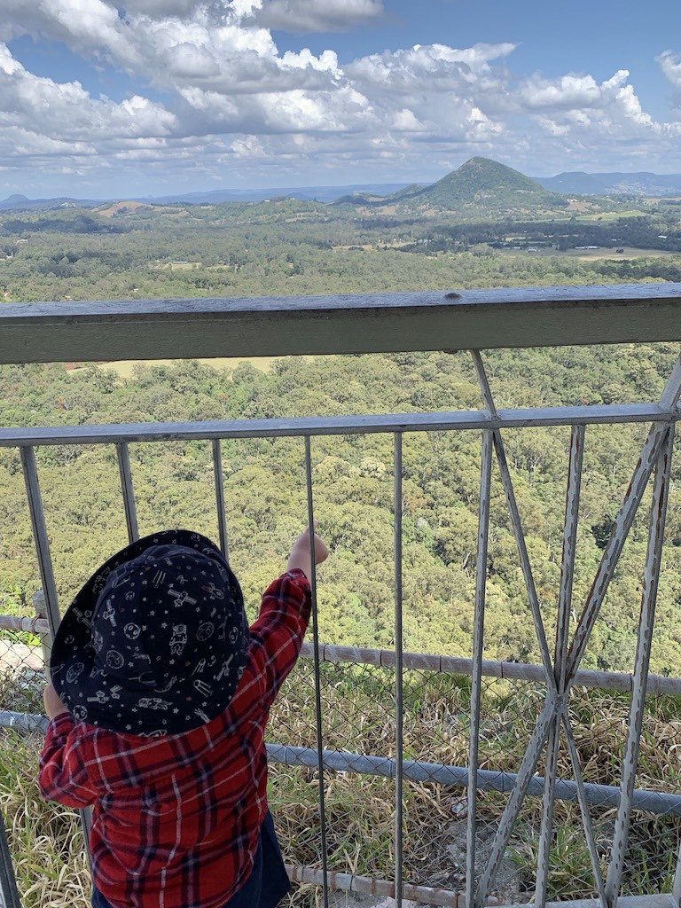 A child pointing at the view from the top of Mout Tinbeerwah